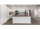 Well-lit kitchen features white cabinets, an island with sink, and stainless steel appliances at 10735 E Kilarea Ave, Mesa, AZ 85209