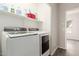 The laundry room features a washer and dryer, and built-in shelving for storage at 10735 E Kilarea Ave, Mesa, AZ 85209