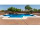 An in-ground pool is the centerpiece of this backyard, surrounded by mature trees at 10735 E Kilarea Ave, Mesa, AZ 85209