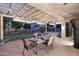 Under-the-pergola view of a backyard with putting green, outdoor furniture, and ambient lighting at 1085 E Oakland Ct, Gilbert, AZ 85295