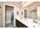 Bright bathroom featuring a double sink vanity with dark wood cabinets, and a shower-tub combo at 1085 E Oakland Ct, Gilbert, AZ 85295