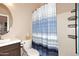 Cozy bathroom featuring a vanity with solid surface countertop and a tub with blue striped shower curtain at 1085 E Oakland Ct, Gilbert, AZ 85295