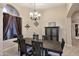 Formal dining room with rustic wood table, elegant chandelier, and decorative wall accents at 1085 E Oakland Ct, Gilbert, AZ 85295