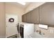 Efficient laundry room featuring modern washer and dryer, ample cabinet storage, and a convenient utility sink at 1085 E Oakland Ct, Gilbert, AZ 85295