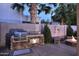 Backyard featuring an outdoor kitchen, fire pit, and desert landscaping at 1085 E Oakland Ct, Gilbert, AZ 85295