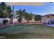 Backyard putting green with manicured landscaping and mature trees at 1085 E Oakland Ct, Gilbert, AZ 85295