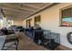 Covered back patio featuring comfortable seating, a grill, and dog kennels at 12043 N 46Th Ave, Glendale, AZ 85304