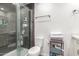 Bathroom with glass enclosed shower, toilet, and shelving for storage and towels at 12043 N 46Th Ave, Glendale, AZ 85304