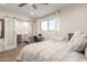 Bedroom featuring sliding barn doors, leading to en-suite, as well as a desk with seating by the window at 12043 N 46Th Ave, Glendale, AZ 85304