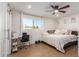 Comfortable bedroom with wood-look tile, ceiling fan, large window with desk, and plenty of natural light at 12043 N 46Th Ave, Glendale, AZ 85304