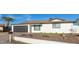 Charming home with a well-maintained front yard, desert landscaping, and a gray garage door at 12043 N 46Th Ave, Glendale, AZ 85304