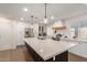 Bright kitchen with white cabinetry, stainless steel appliances, and a large island with quartz countertop at 12043 N 46Th Ave, Glendale, AZ 85304