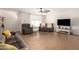 Inviting living room featuring wood-look tile floors, a ceiling fan, and comfortable seating at 12043 N 46Th Ave, Glendale, AZ 85304