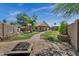 Backyard view showcasing play structure, patio, firepit, manicured lawn, and privacy landscaping at 1245 W Cindy St, Chandler, AZ 85224