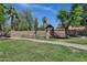 Backyard featuring a playhouse with a slide and swings, surrounded by green grass at 1245 W Cindy St, Chandler, AZ 85224