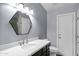 Bathroom features a hexagon mirror, modern lighting, sleek countertops, and under-sink storage at 1245 W Cindy St, Chandler, AZ 85224