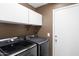 Laundry room features newer washer/dryer, upper cabinets, and access door at 1245 W Cindy St, Chandler, AZ 85224