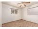 Well-lit bedroom with tile floors, a ceiling fan, and a bright window that filters in natural light at 125 E Loma Ln, Phoenix, AZ 85020
