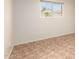Bright, open bedroom featuring light-colored walls, tile flooring, and a window view of the backyard at 125 E Loma Ln, Phoenix, AZ 85020