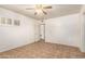 Bedroom boasts tile flooring, white walls, and a ceiling fan for a bright aesthetic at 125 E Loma Ln, Phoenix, AZ 85020