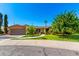 Charming brick home with a two-car garage, mature trees, and a well-manicured lawn at 125 E Loma Ln, Phoenix, AZ 85020