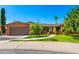 Charming brick home with a two-car garage, mature trees, and a well-manicured lawn at 125 E Loma Ln, Phoenix, AZ 85020