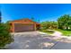 Brick home featuring a spacious two-car garage and a beautifully landscaped front yard at 125 E Loma Ln, Phoenix, AZ 85020