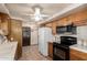 Kitchen features wood cabinets, white appliances, and tile countertops at 125 E Loma Ln, Phoenix, AZ 85020
