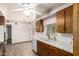 Kitchen boasting tile counters, a ceiling fan, and wood cabinets at 125 E Loma Ln, Phoenix, AZ 85020