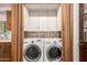 Convenient laundry area with modern washer and dryer, surrounded by cabinets and classic wood trim at 125 E Loma Ln, Phoenix, AZ 85020