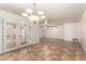 Spacious living room boasting tile floors, a chandelier, and elegant French doors at 125 E Loma Ln, Phoenix, AZ 85020