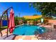 Beautiful in-ground swimming pool with a slide and shaded seating area, perfect for summer fun at 125 E Loma Ln, Phoenix, AZ 85020