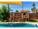In-ground swimming pool featuring a unique sun shade, slide and chicken coop for a relaxing and playful retreat at 125 E Loma Ln, Phoenix, AZ 85020