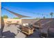 Charming backyard featuring stylish seating, shade sail, string lights, and gravel groundcover for relaxation and entertaining at 1451 E South Fork Dr, Phoenix, AZ 85048