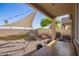 The cozy backyard features a large table, hammock, shade sail, and desert landscaping at 1451 E South Fork Dr, Phoenix, AZ 85048