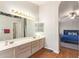Bright bathroom with dual sink vanity, arched doorway, and wood-look floors at 1451 E South Fork Dr, Phoenix, AZ 85048