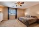 Cozy primary bedroom with carpet flooring, a ceiling fan, and a large window with curtains at 1585 E Jeanne Ln, San Tan Valley, AZ 85140