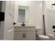 Well-lit bathroom featuring a vanity with a dark faucet, toilet, and shower at 18240 W La Senda Dr, Surprise, AZ 85387
