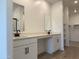 Bathroom with double sink vanity, mirrors, and wood-look tile flooring at 18240 W La Senda Dr, Surprise, AZ 85387