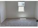 Cozy bedroom featuring neutral carpet, a bright window and fresh paint at 18240 W La Senda Dr, Surprise, AZ 85387