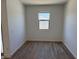 Empty room with hardwood floors, window, and neutral-colored walls at 18240 W La Senda Dr, Surprise, AZ 85387