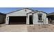 Charming single-story home with stucco siding, a dark brown garage door, and low-maintenance landscaping at 18240 W La Senda Dr, Surprise, AZ 85387
