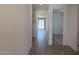 Bright hallway with wood-look tile flooring leading to a room with a sliding glass door at 18240 W La Senda Dr, Surprise, AZ 85387