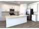 Modern kitchen with white cabinets, stainless steel appliances, and a center island with a sink at 18240 W La Senda Dr, Surprise, AZ 85387