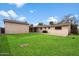 Backyard view featuring a grass lawn, concrete patio, the house, and the detached garage at 255 N Hunt E Dr, Mesa, AZ 85203