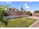 Backyard with artificial grass, mature landscaping, and a block fence at 2759 E Mews Rd, Gilbert, AZ 85298
