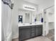 Bathroom featuring dual sinks, gray vanity, modern lighting, and a combination tub and shower at 2759 E Mews Rd, Gilbert, AZ 85298