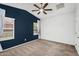 Bedroom featuring plush carpet, ceiling fan, natural light from the large windows, and navy accent wall at 2759 E Mews Rd, Gilbert, AZ 85298