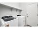 Bright laundry room featuring a Whirlpool washer and dryer and shelving at 2759 E Mews Rd, Gilbert, AZ 85298