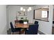 Modern dining room with a round wooden table and four blue chairs at 3802 W Mulberry Dr, Phoenix, AZ 85019